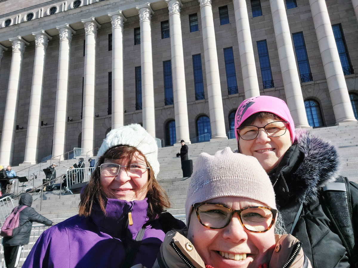 Three women in front of a large building