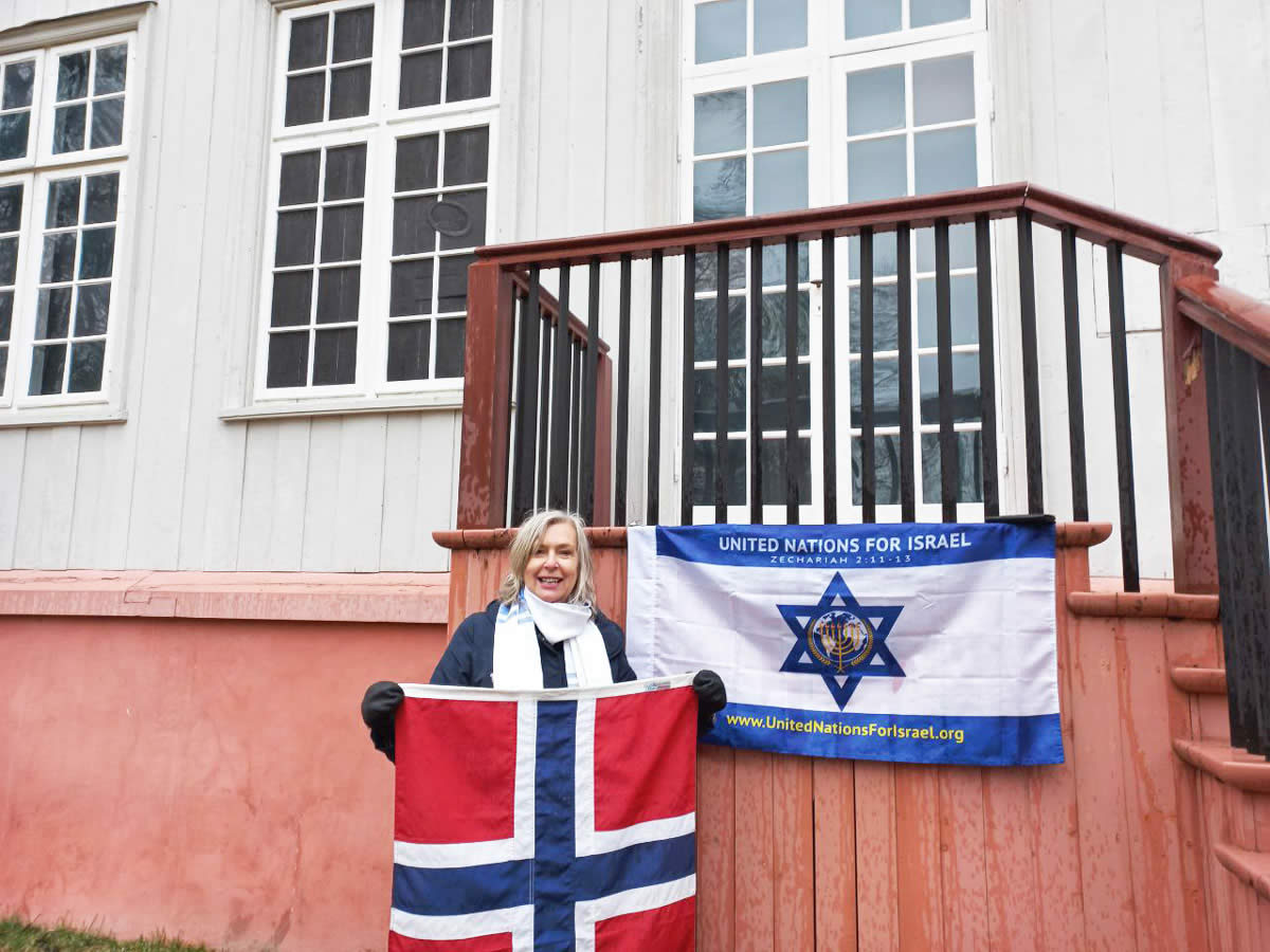 Woman holding Norwegian flag next to UNIFY flag