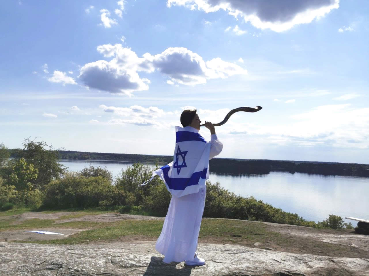 Woman in Norway wearing Israeli flag blowing shofar