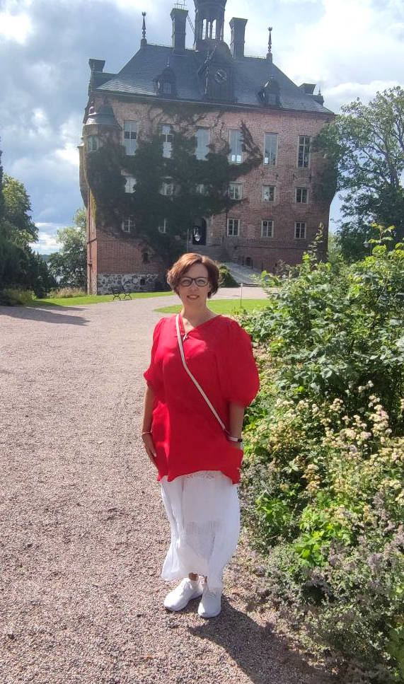 Woman in red in front of a big building