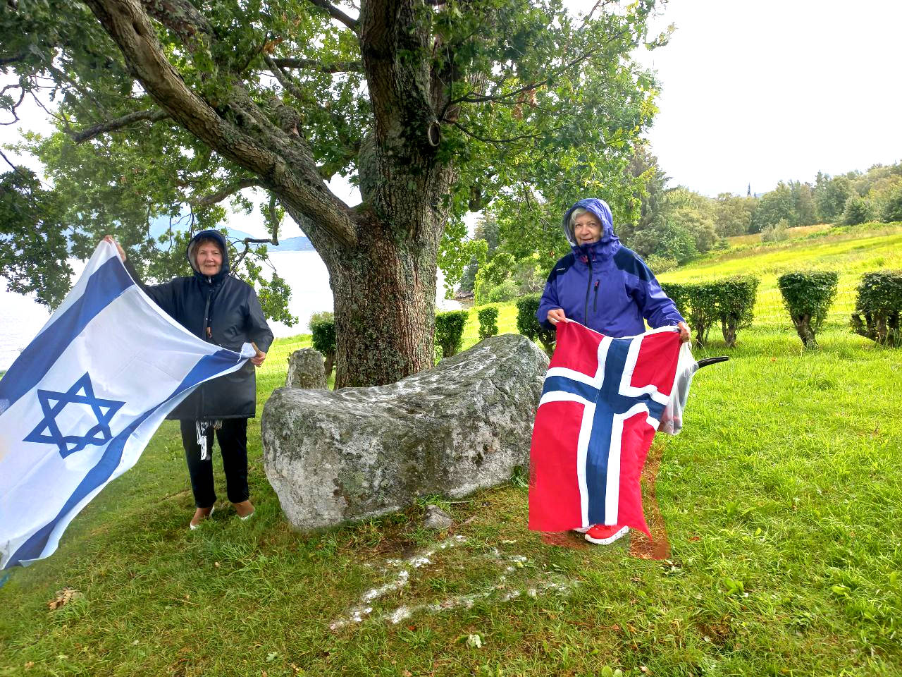 Women with Israel and Norway flag under a tree