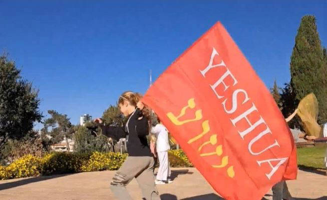 Girl holding Yeshua flag